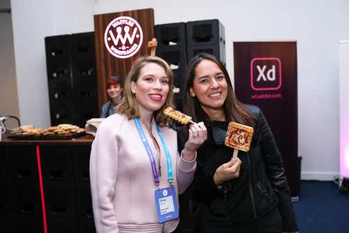 Two women enjoying waffles from the Waffles and Wireframes stand.
